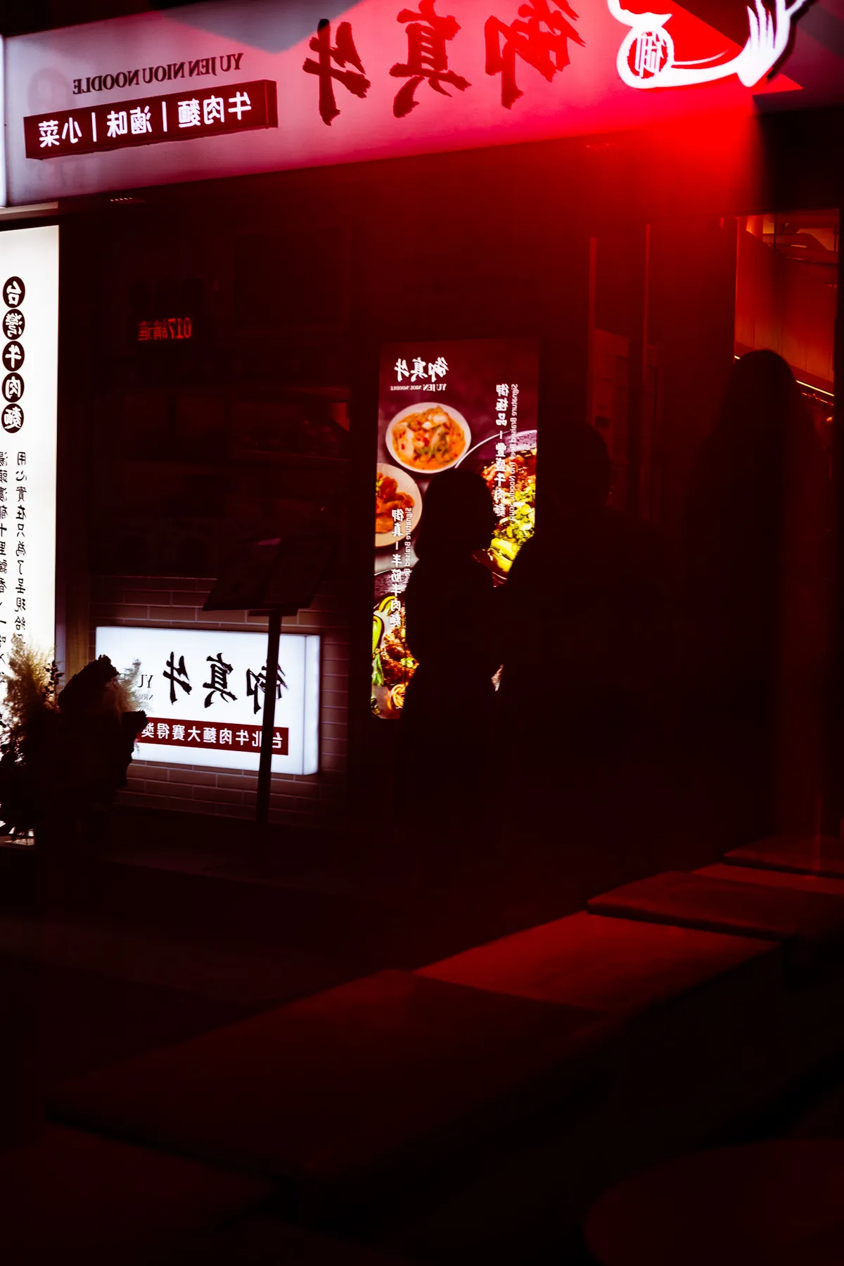 Neon signs illuminating a rainy street